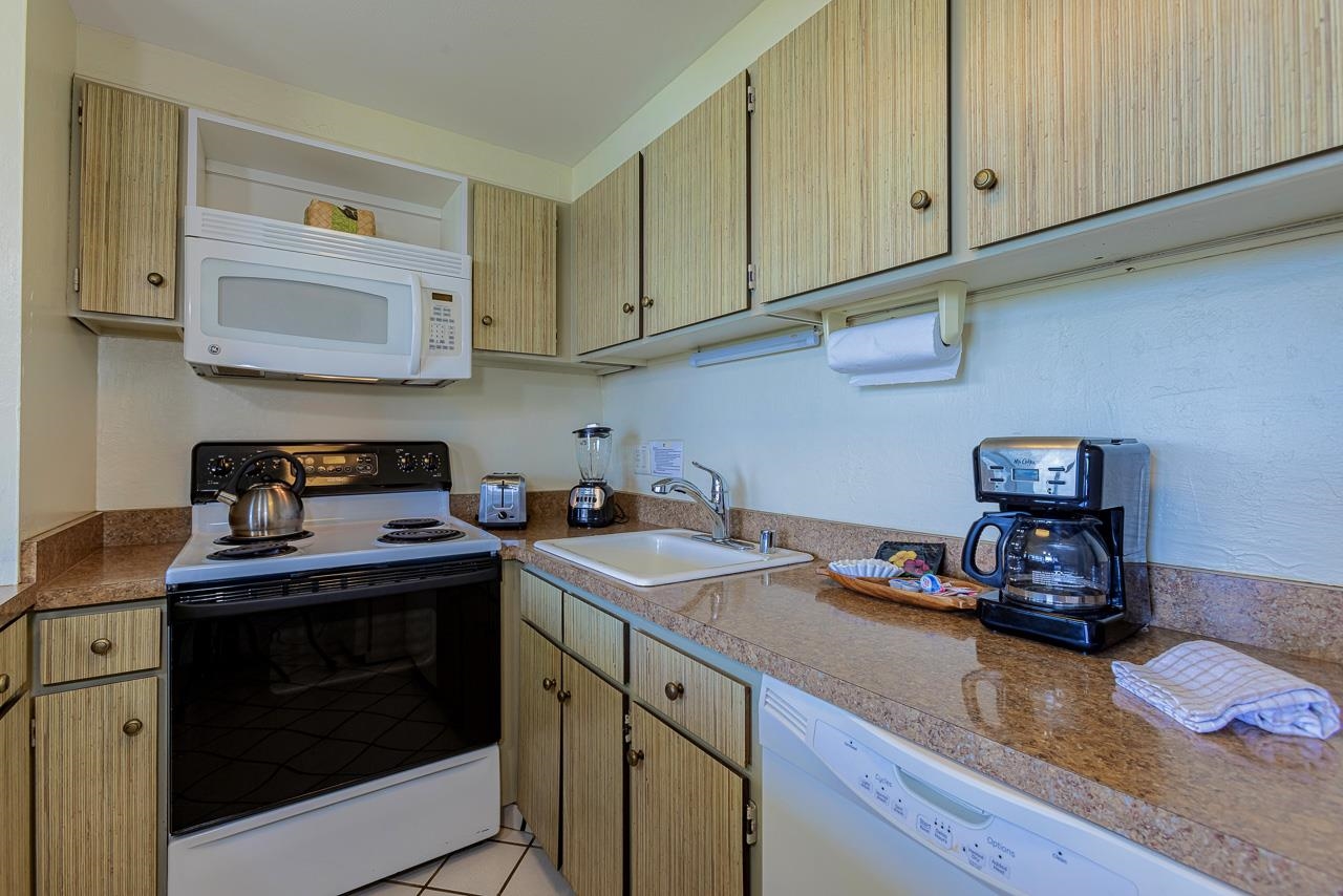2936 South Kihei Road, Unit 613 Kihei, HI 96753 - Photo 15 of 46 a kitchen with stainless steel appliances granite countertop a sink stove and cabinets