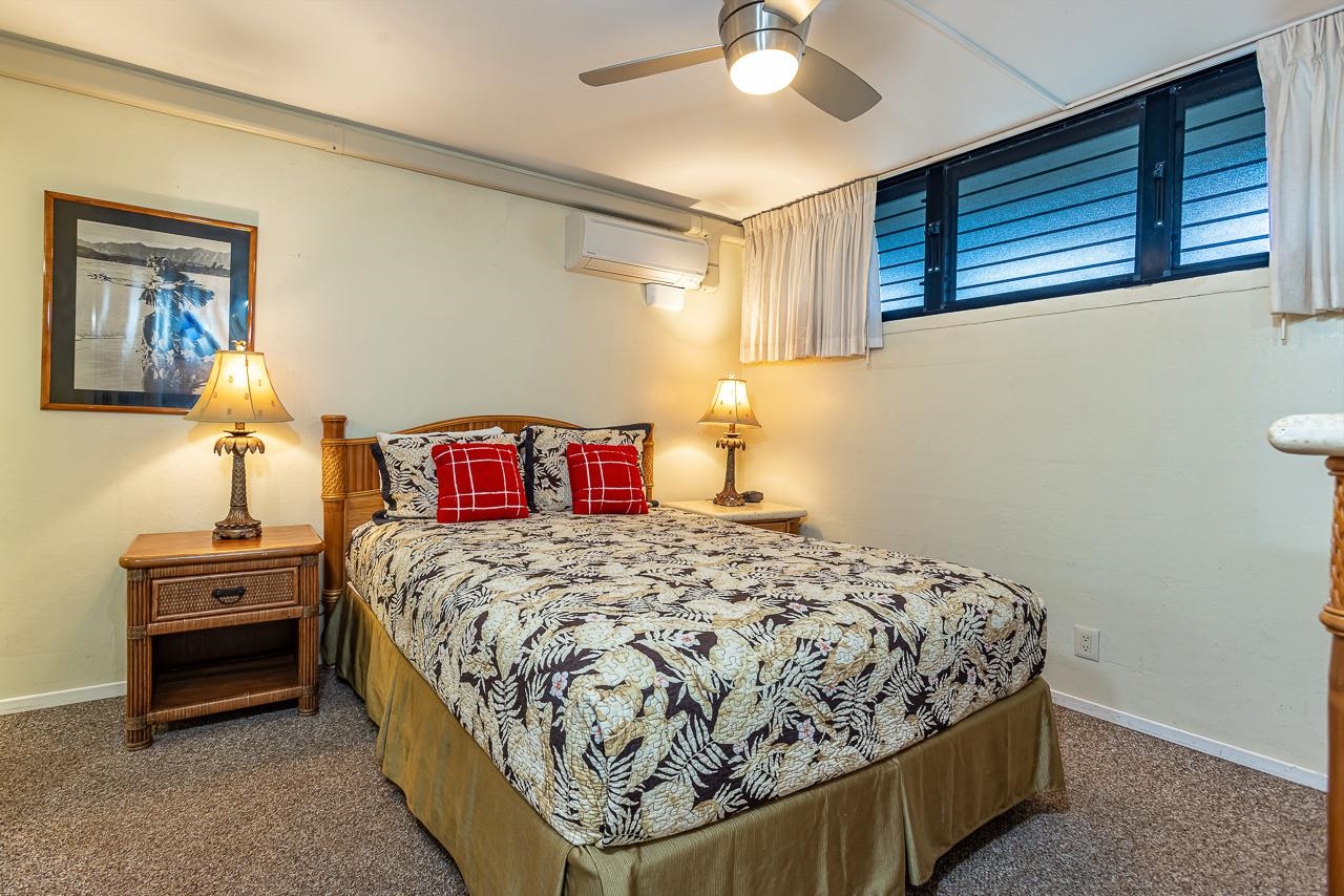 2936 South Kihei Road, Unit 613 Kihei, HI 96753 - Photo 19 of 46 a bedroom with a bed and a chandelier