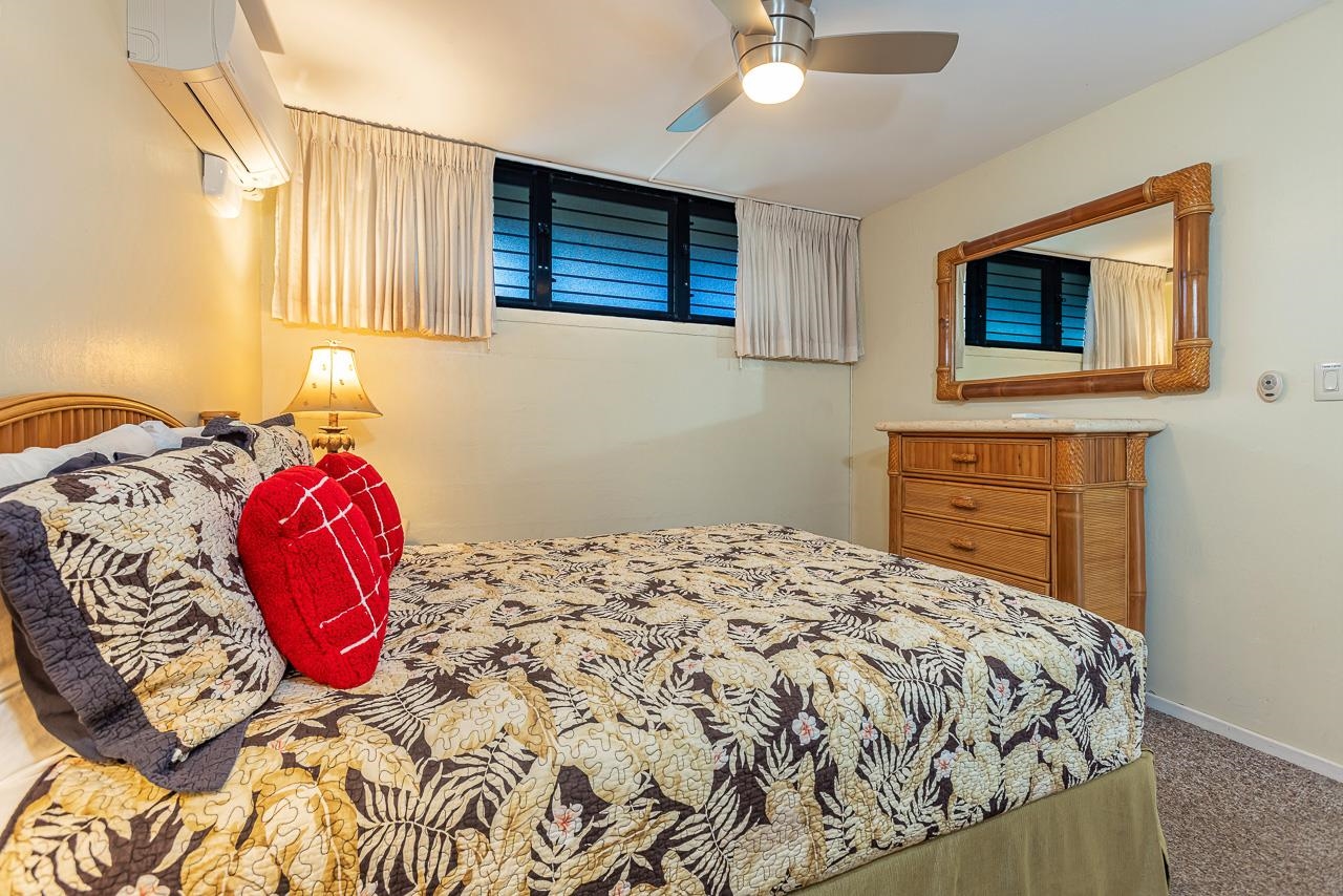 2936 South Kihei Road, Unit 613 Kihei, HI 96753 - Photo 20 of 46 a bedroom with a bed and a painting on the wall