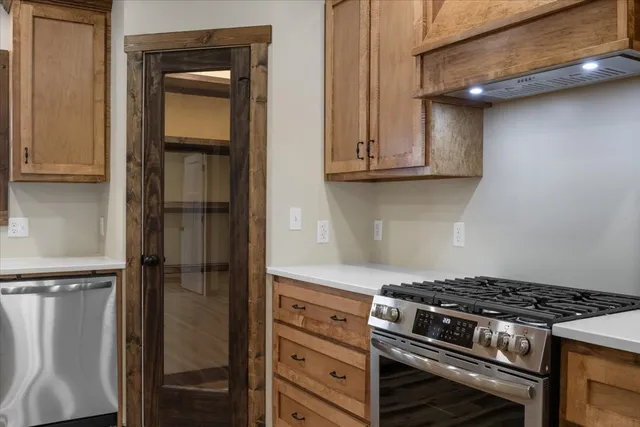 a kitchen with stainless steel appliances kitchen island granite countertop a refrigerator and a stove top oven