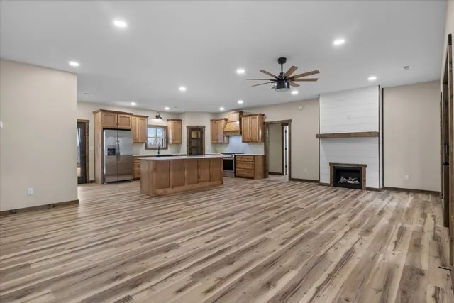 a kitchen with stainless steel appliances kitchen island granite countertop a stove a sink and a refrigerator