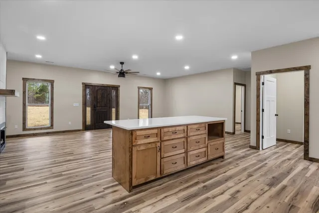 a view of an empty room with window and wooden floor