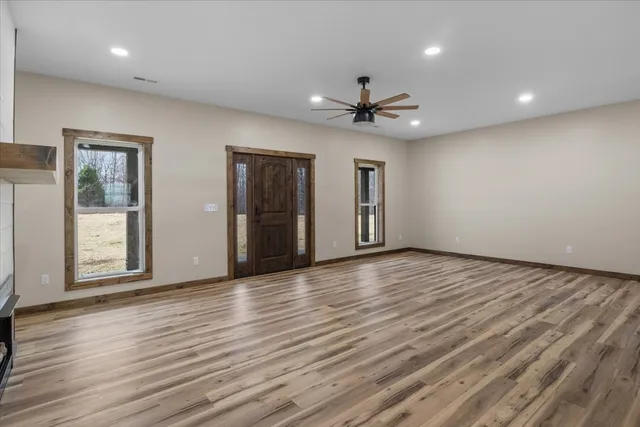 a view of empty room with wooden floor and fireplace