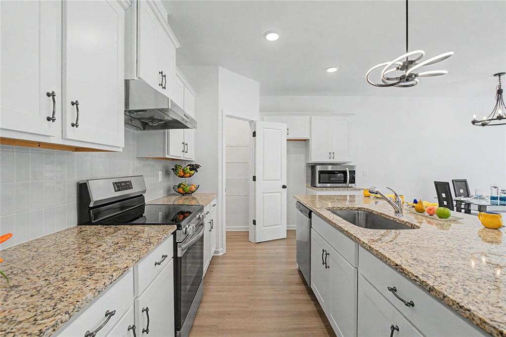 2310 Portrush Way Southeast Atlanta, GA 30339 - Photo 11 of 38 a kitchen with stainless steel appliances granite countertop a sink stove and refrigerator