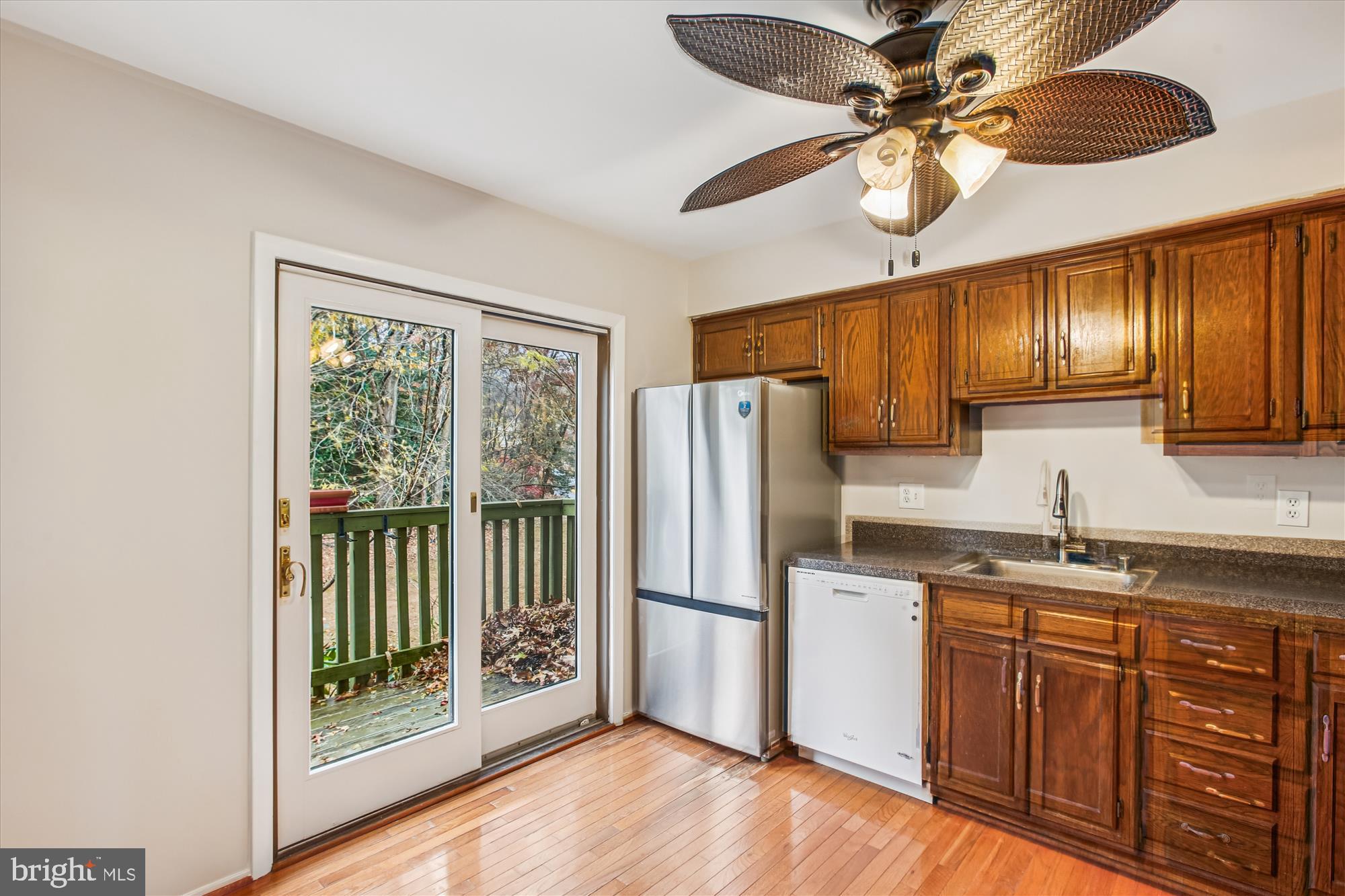 2025 Winged Foot Court Reston, VA 20191 - Photo 14 of 59 a kitchen with stainless steel appliances granite countertop a refrigerator a sink dishwasher a kitchen island with wooden cabinets and floor