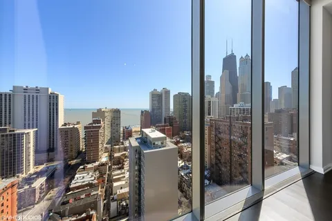 a large white kitchen with granite countertop a large window and a sink