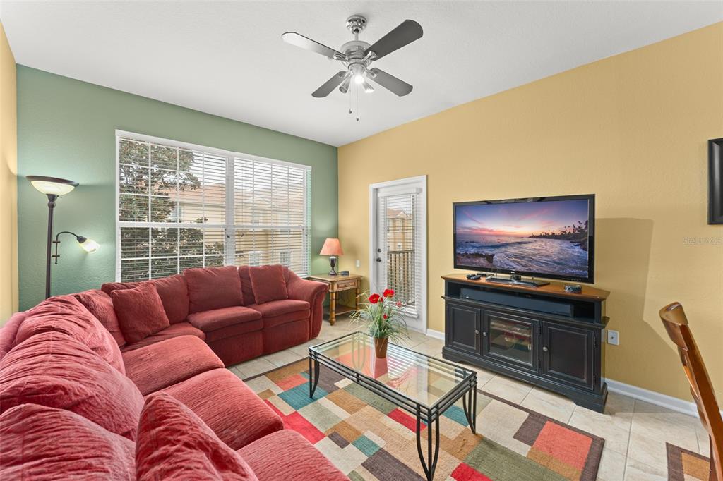 7675 Comrow Street, Unit 405 Kissimmee, FL 34747 - Photo 11 of 40 a living room with furniture and a flat screen tv