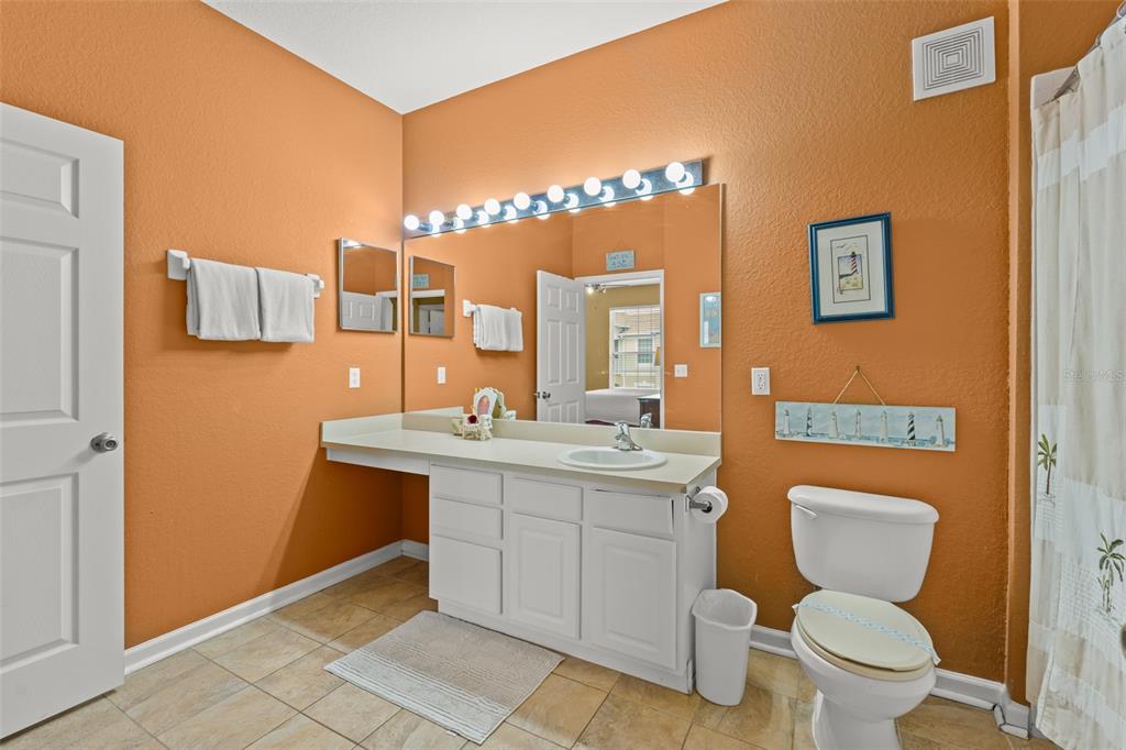 7675 Comrow Street, Unit 405 Kissimmee, FL 34747 - Photo 27 of 40 a bathroom with a toilet sink vanity and mirror