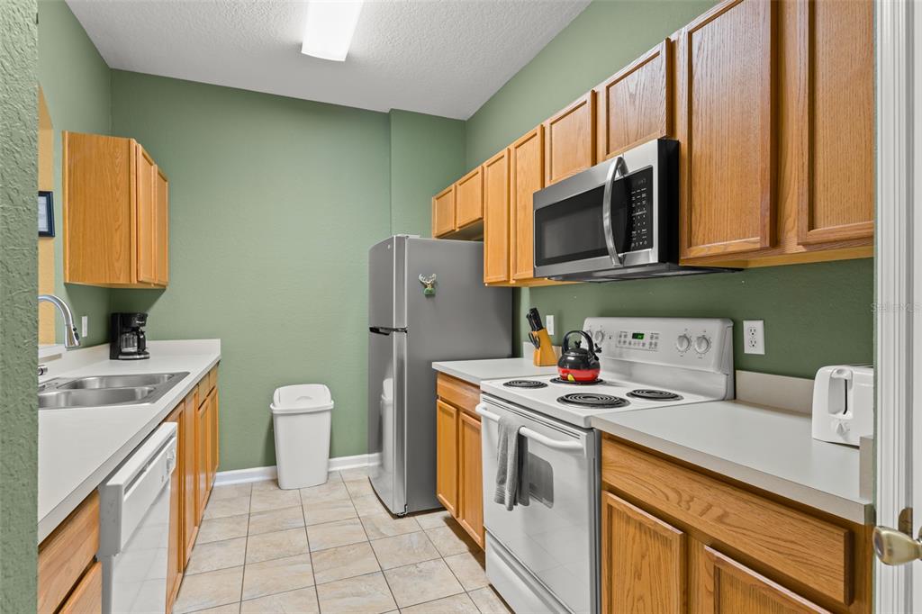 7675 Comrow Street, Unit 405 Kissimmee, FL 34747 - Photo 5 of 40 a kitchen with a sink stove and refrigerator