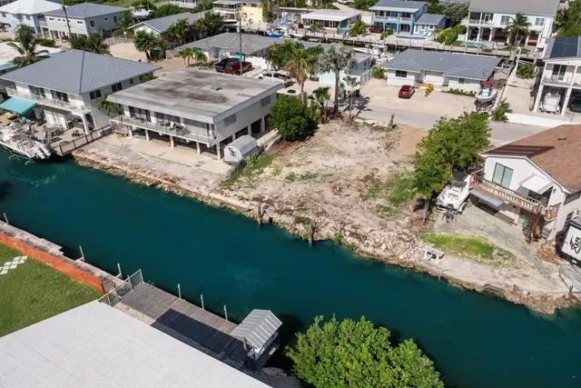 an aerial view of a house with a garden and lake view