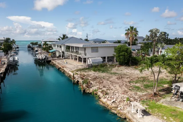 a view of a house with yard and lake view