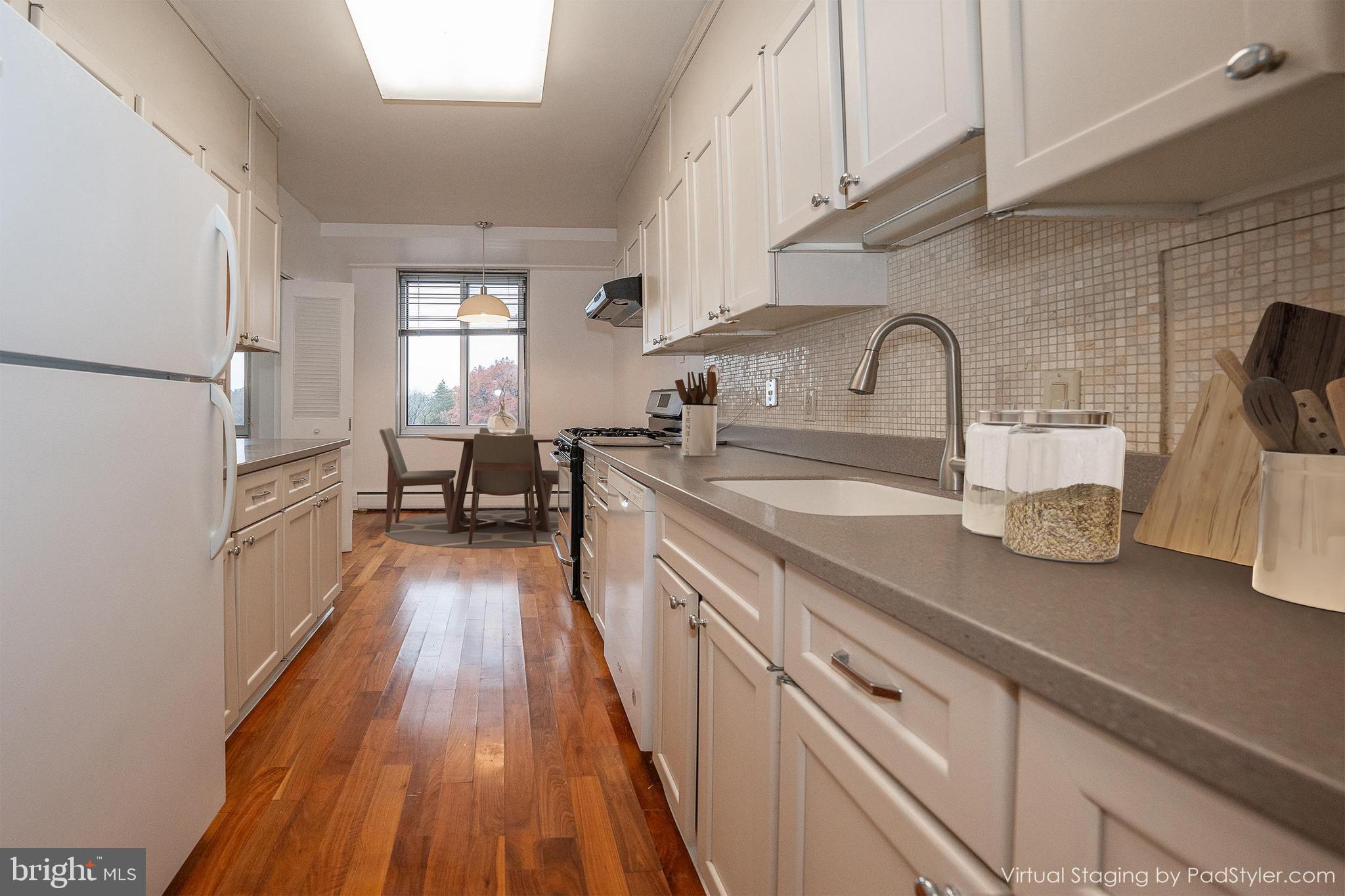 191 Presidential Boulevard, Unit R402 Bala Cynwyd, PA 19004 - Photo 9 of 27 a kitchen with sink a stove and wooden floor