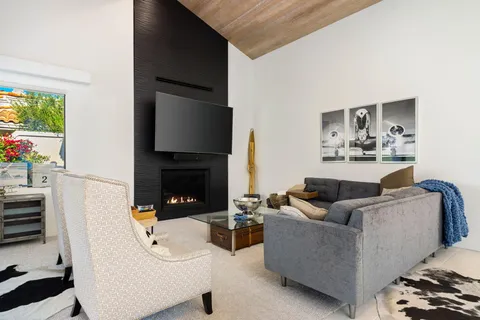 a living room with furniture fireplace and a large window