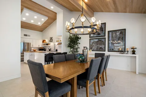 a table and chairs with the view of tree in front of it