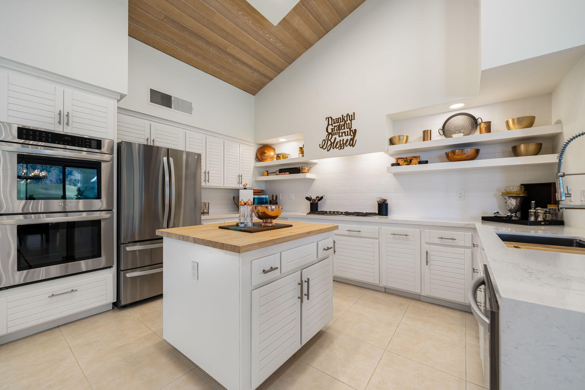 54885 Inverness Way La Quinta, CA 92253 - Photo 35 of 53 a kitchen with stainless steel appliances a stove a refrigerator and cabinets