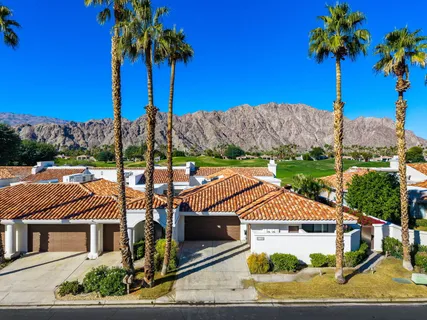 a view of a house with a yard and potted plants