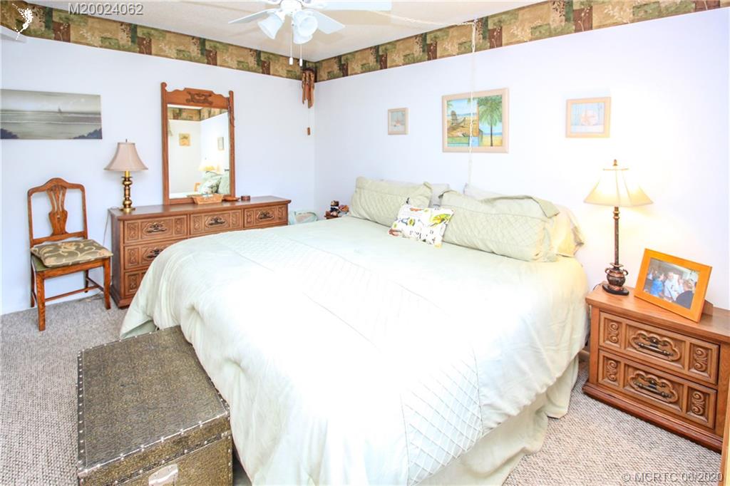2950 Southeast Ocean Boulevard, Unit 101 Stuart, FL 34996 - Photo 15 of 29 a spacious bedroom with a bed and a dresser in it