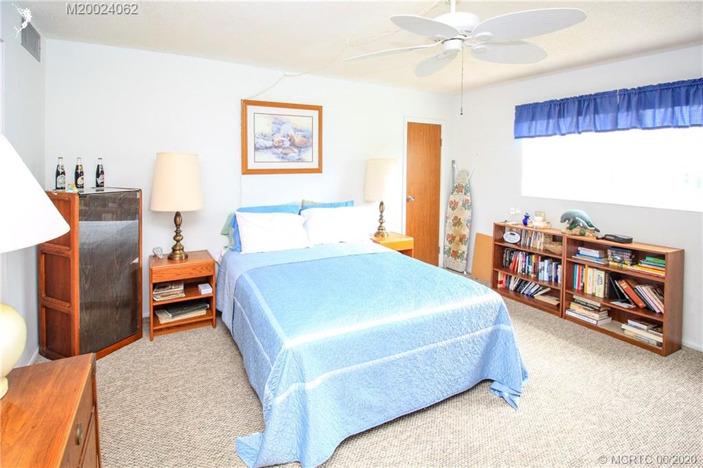 2950 Southeast Ocean Boulevard, Unit 101 Stuart, FL 34996 - Photo 17 of 29 a bedroom with a bed and a night stand