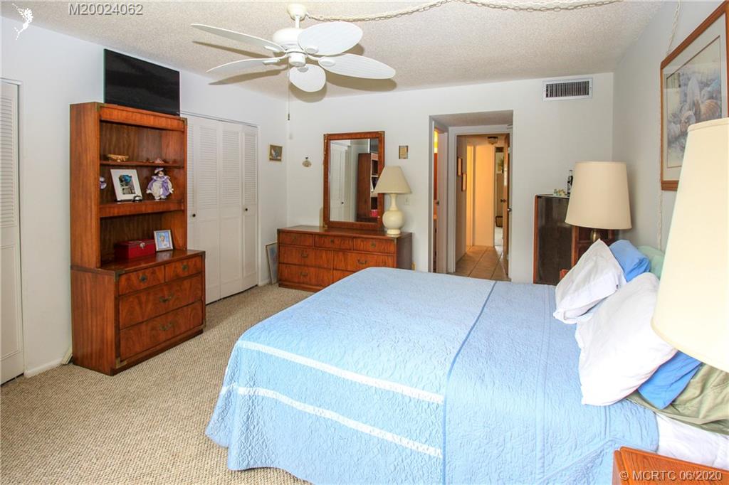 2950 Southeast Ocean Boulevard, Unit 101 Stuart, FL 34996 - Photo 18 of 29 a bed room with a bed and a television