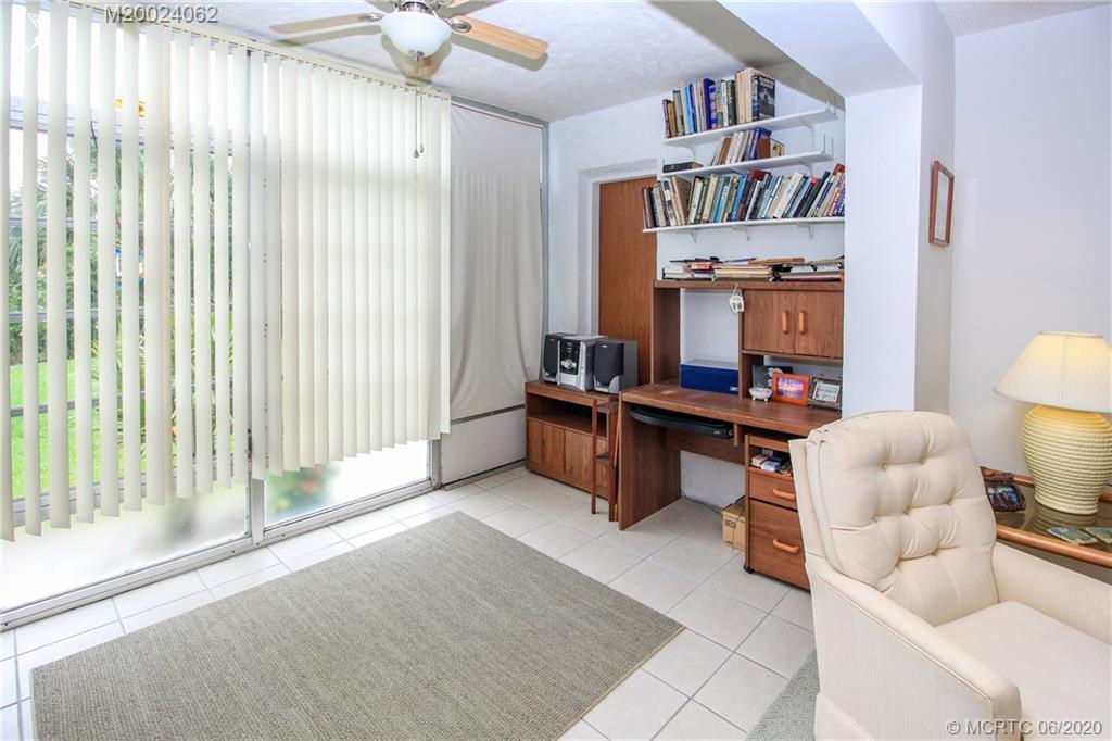2950 Southeast Ocean Boulevard, Unit 101 Stuart, FL 34996 - Photo 20 of 29 a living room with furniture and a book shelf