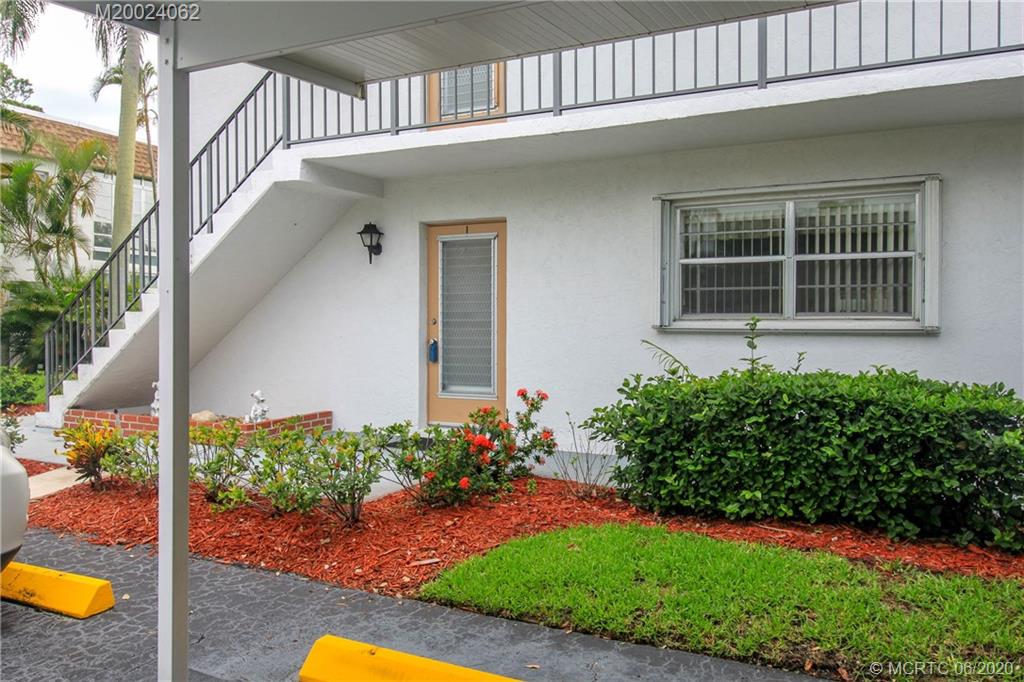 2950 Southeast Ocean Boulevard, Unit 101 Stuart, FL 34996 - Photo 2 of 29 a front view of a house with garden