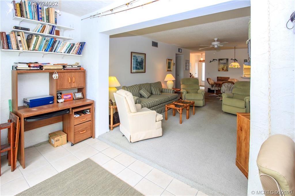 2950 Southeast Ocean Boulevard, Unit 101 Stuart, FL 34996 - Photo 21 of 29 a living room with furniture and a shelf