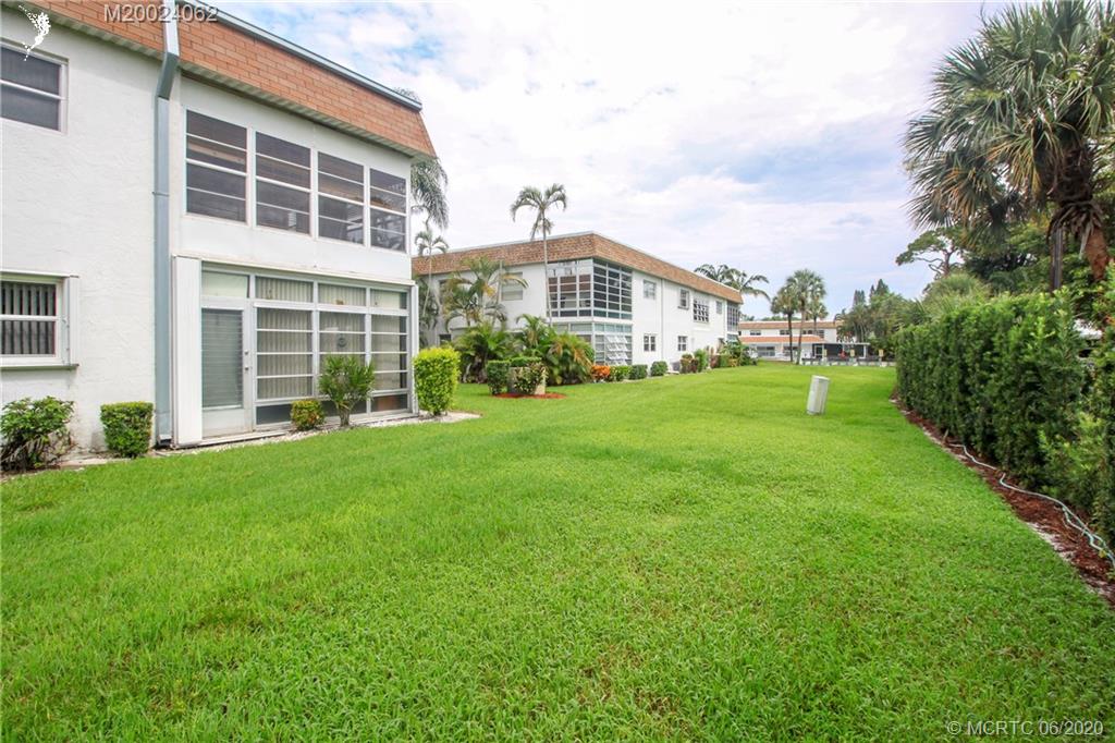 2950 Southeast Ocean Boulevard, Unit 101 Stuart, FL 34996 - Photo 23 of 29 a front view of a house with a yard