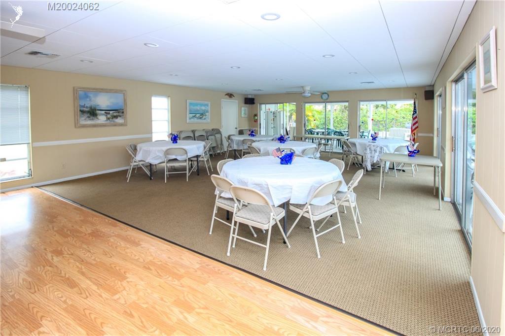 2950 Southeast Ocean Boulevard, Unit 101 Stuart, FL 34996 - Photo 28 of 29 a dining room with furniture a rug and a large window
