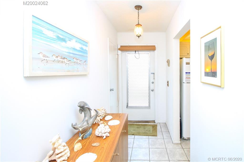 2950 Southeast Ocean Boulevard, Unit 101 Stuart, FL 34996 - Photo 3 of 29 a bed room with a bed and a painting on the wall