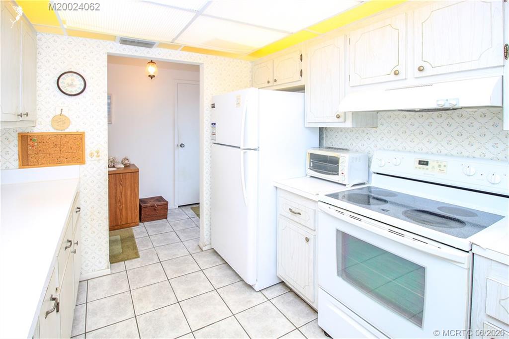 2950 Southeast Ocean Boulevard, Unit 101 Stuart, FL 34996 - Photo 5 of 29 a kitchen with a refrigerator and cabinets