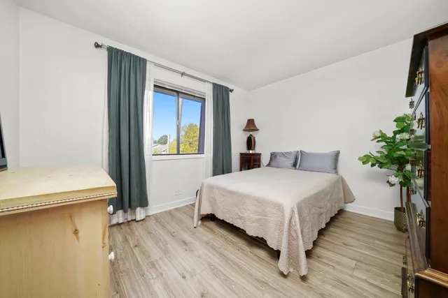 a bedroom with a bed and a potted plant