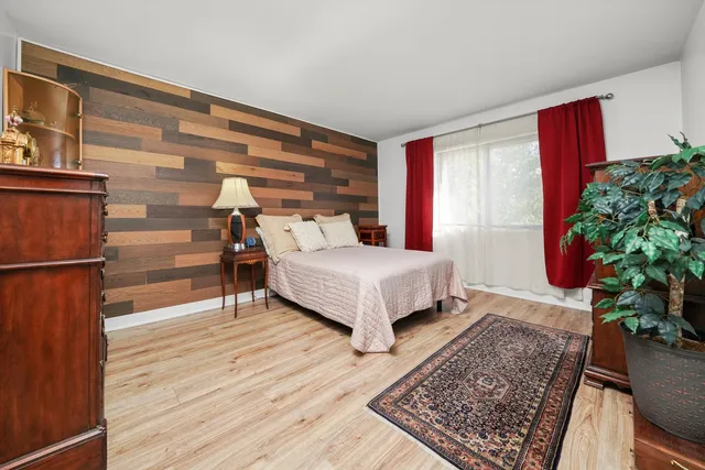 a bedroom with a bed lamp and a potted plant