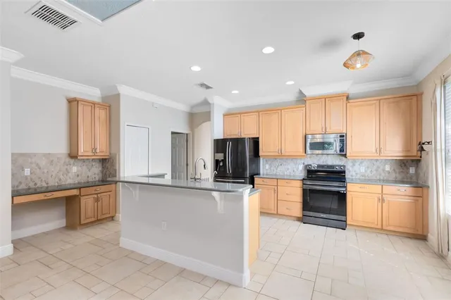 a kitchen with stainless steel appliances granite countertop a stove top oven a sink and a refrigerator