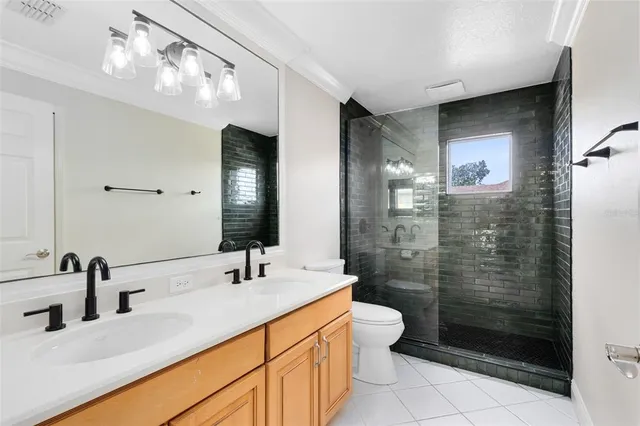 a bathroom with a double vanity sink toilet and shower