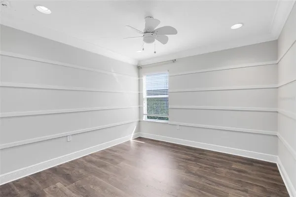 a view of an empty room with a window and wooden floor