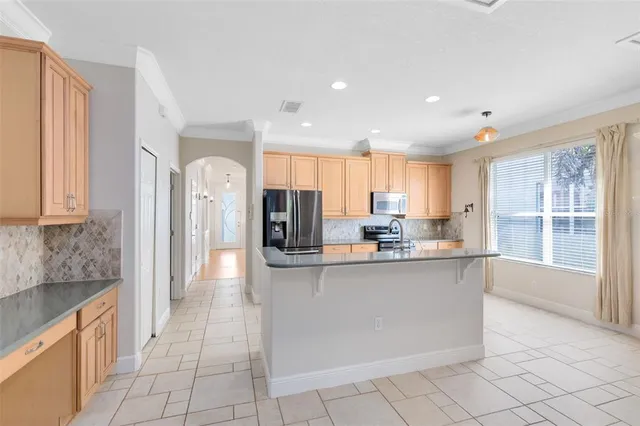 a kitchen with stainless steel appliances granite countertop a refrigerator and a sink