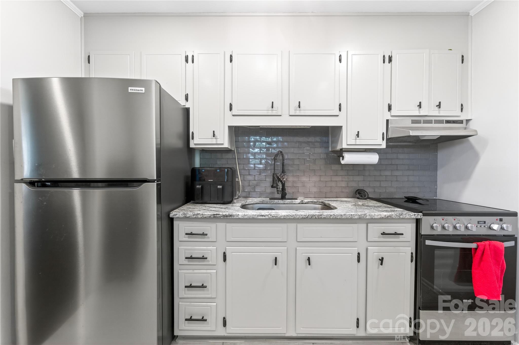 3241 Minnesota Road Charlotte, NC 28208 - Photo 12 of 18 a kitchen with stainless steel appliances granite countertop a refrigerator a stove a sink and white cabinets