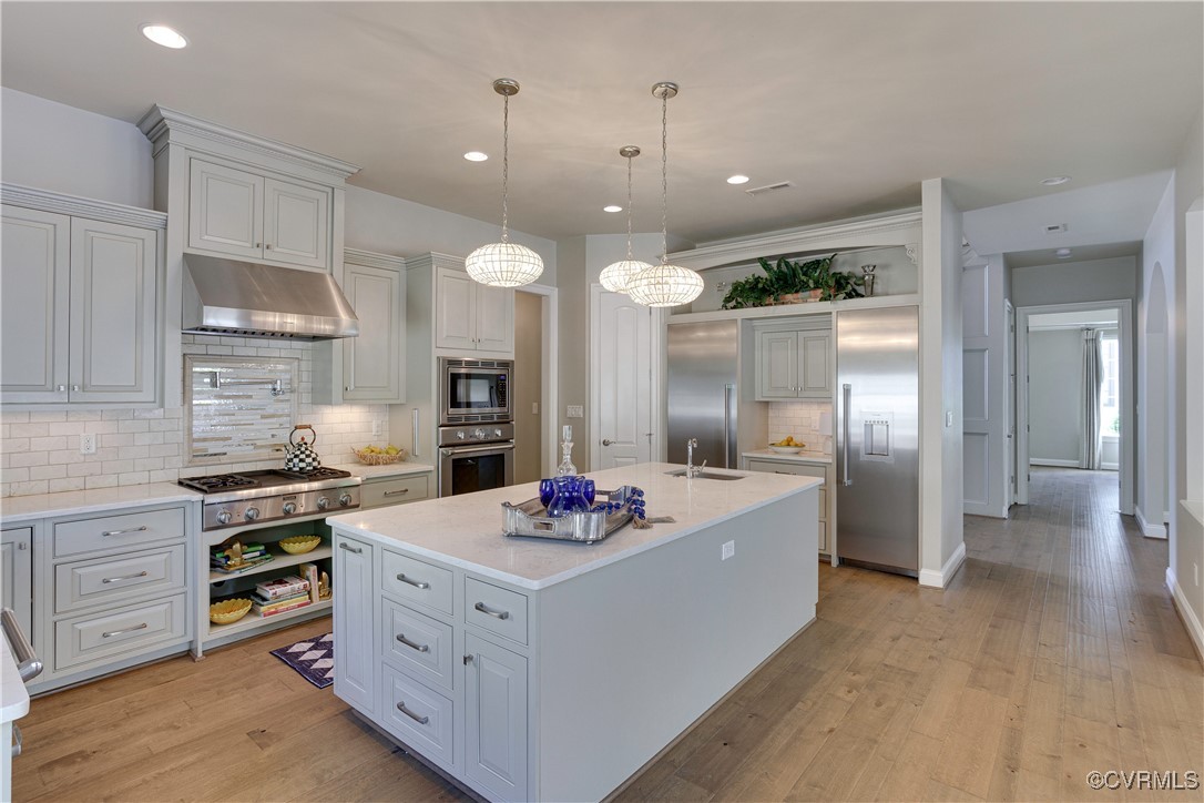 2392 Bel Crest Circle Midlothian, VA 23113 - Photo 12 of 50 a kitchen with stainless steel appliances kitchen island granite countertop a stove a sink a refrigerator and white cabinets with wooden floor