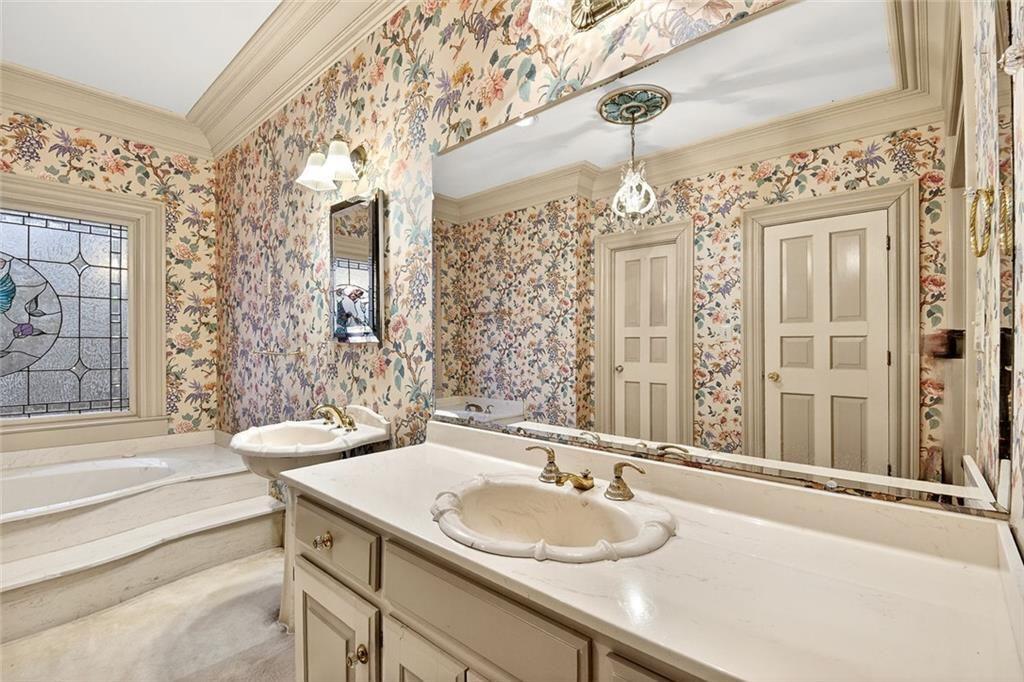 5523 Bahia Mar Circle Smoke Rise, GA 30087 - Photo 31 of 69 a bathroom with a granite countertop sink a large mirror and a shower