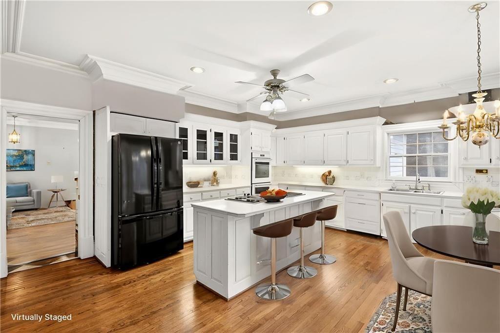 5523 Bahia Mar Circle Smoke Rise, GA 30087 - Photo 44 of 69 a kitchen with kitchen island a stove a refrigerator and a dining table with wooden floors