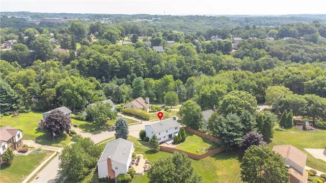 an aerial view of residential houses with outdoor space and trees