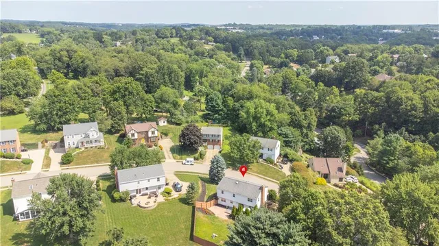 a aerial view of a house with swimming pool and large trees
