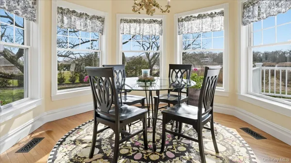 a view of a dining room with furniture large windows and wooden floor