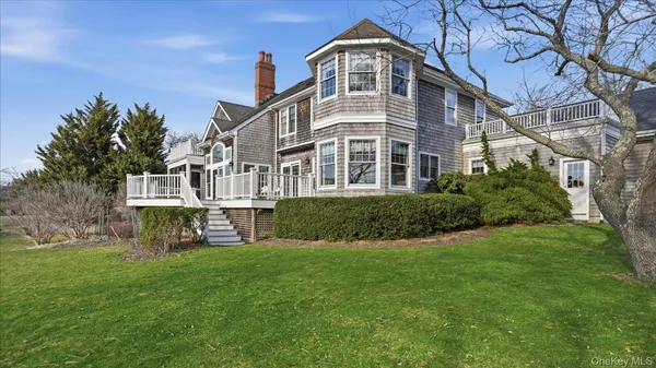 a backyard of a house with lots of green space and lake view