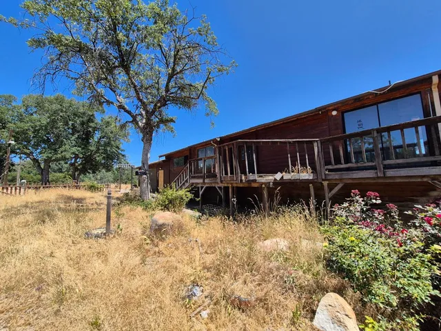 a backyard of a house with lots of green space and fountain
