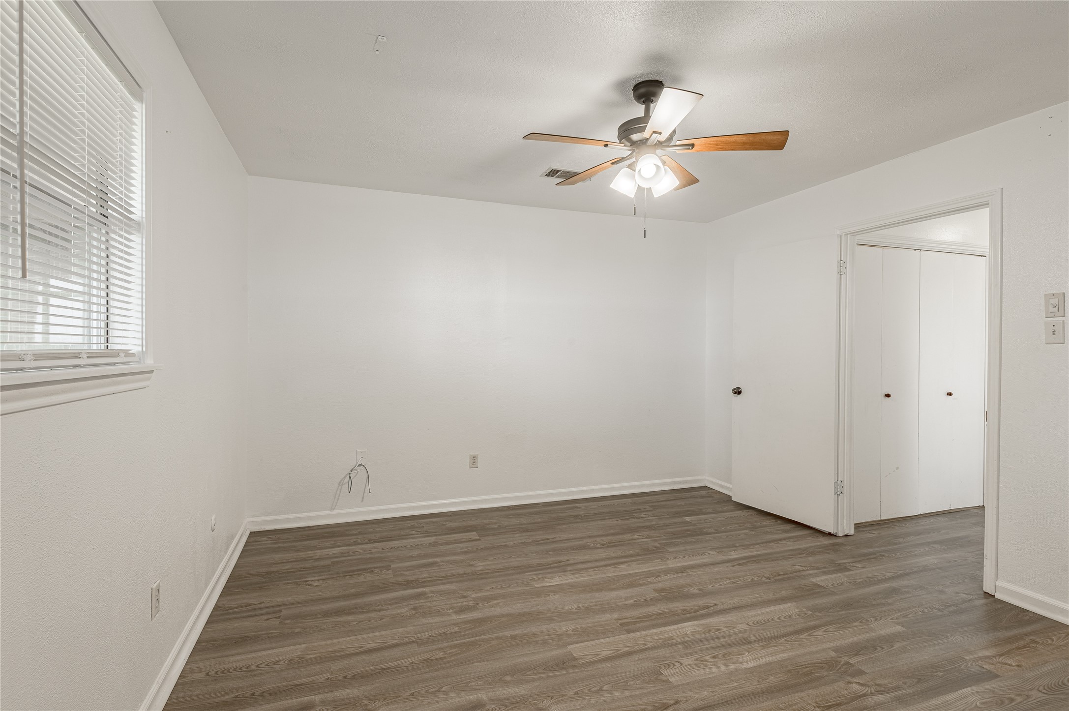 114 Timberline Drive Huntsville, TX 77320 - Photo 20 of 26 an empty room with wooden floor fan and windows