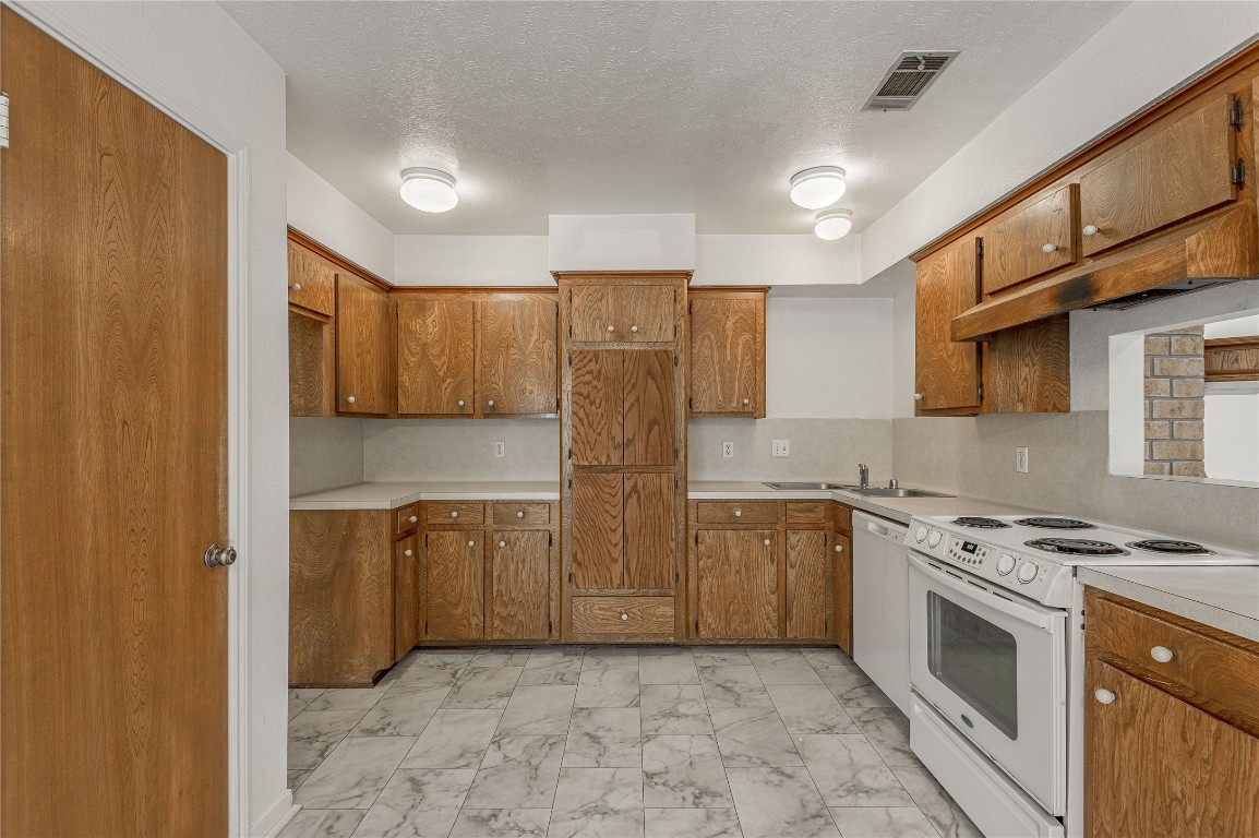 114 Timberline Drive Huntsville, TX 77320 - Photo 5 of 26 a kitchen with stainless steel appliances granite countertop a stove and a refrigerator