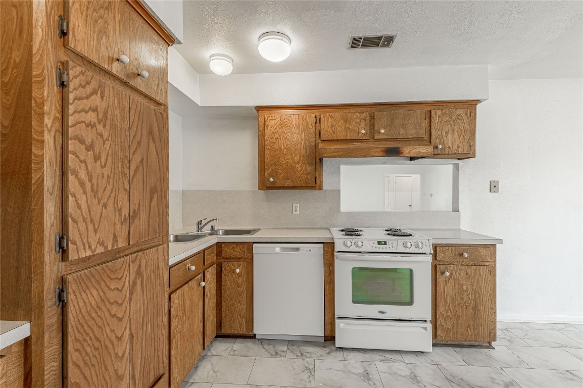 114 Timberline Drive Huntsville, TX 77320 - Photo 7 of 26 a kitchen with stainless steel appliances granite countertop a stove a sink and a refrigerator