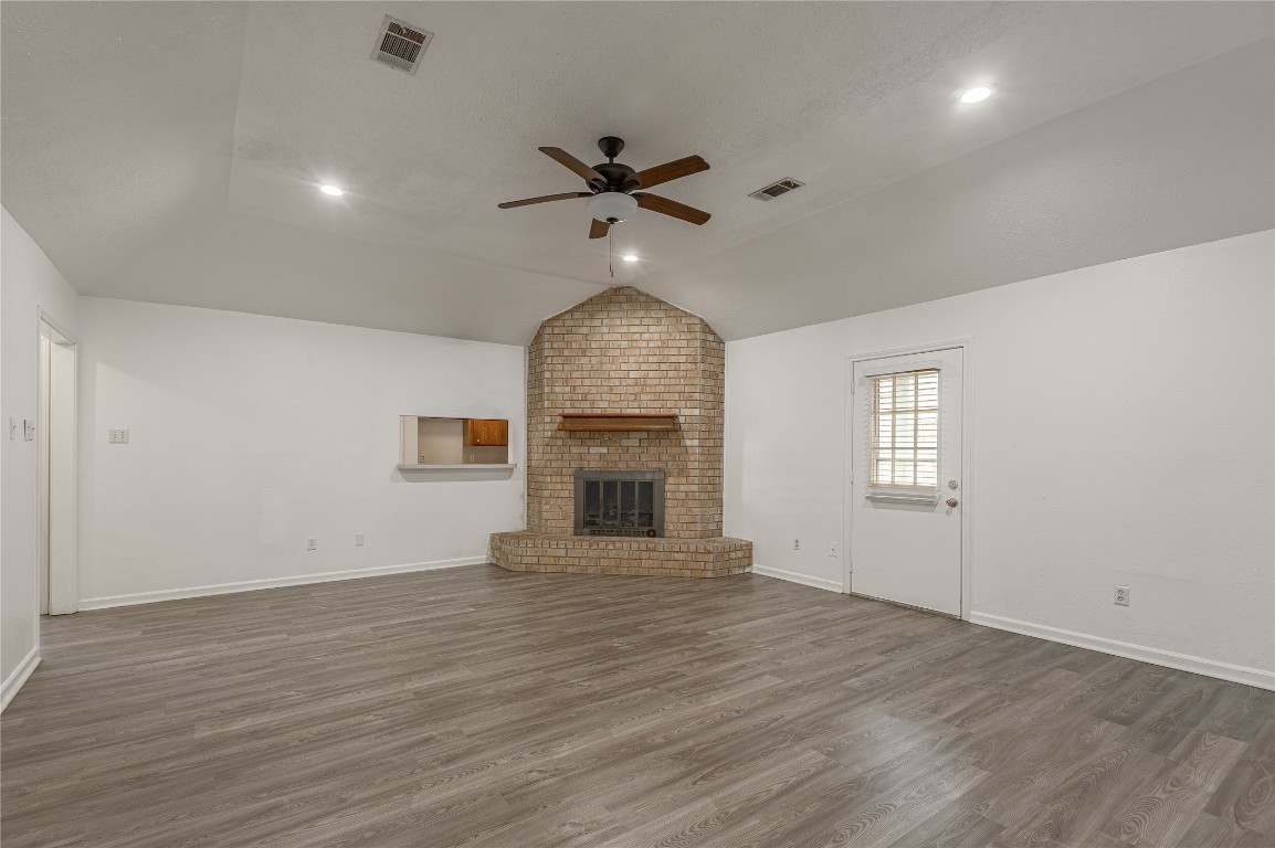 114 Timberline Drive Huntsville, TX 77320 - Photo 10 of 26 an empty room with wooden floor chandelier fan and windows