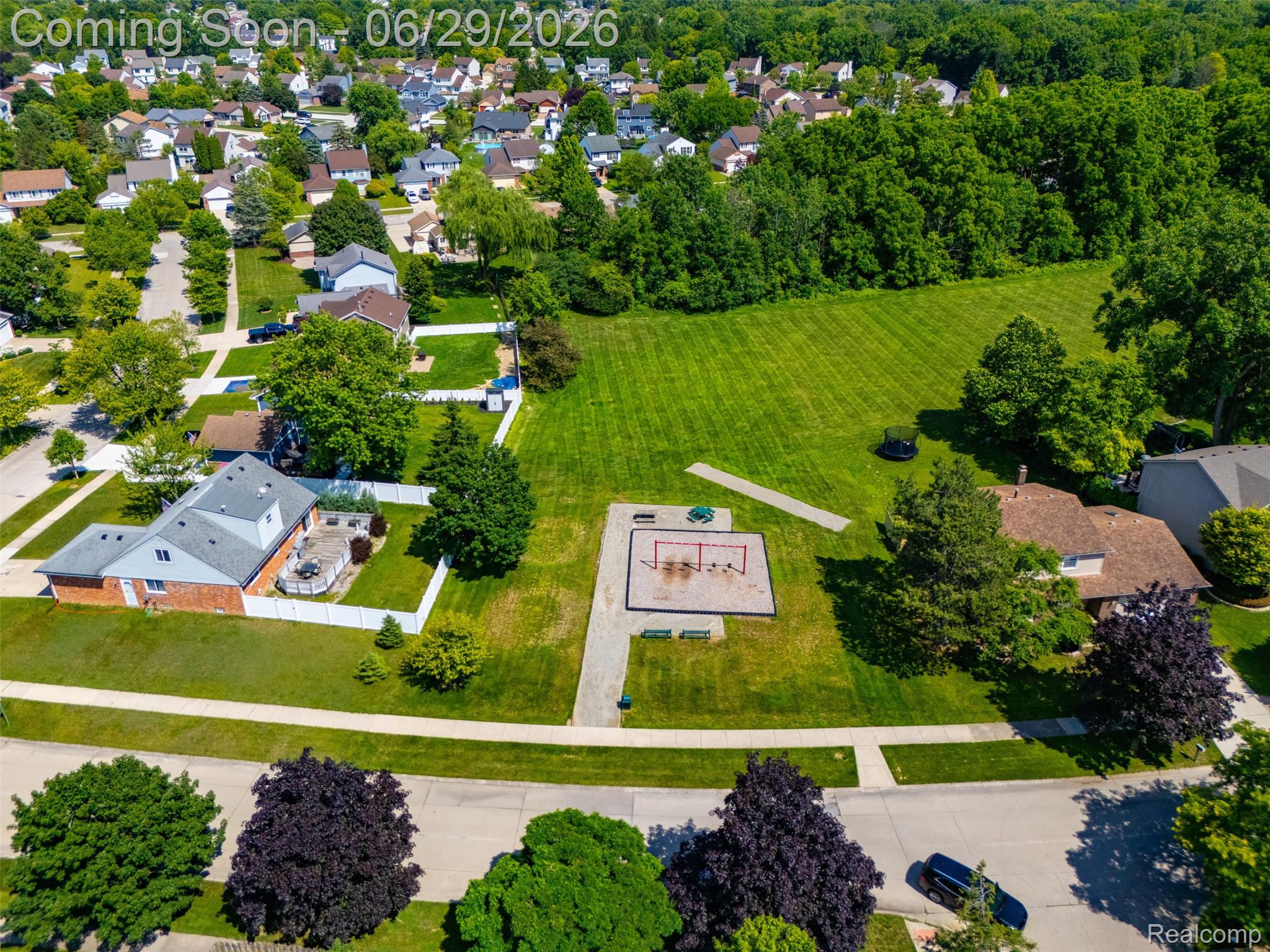 45179 Rudgate Road Canton, MI 48188 - Photo 40 of 48 Expansive green space featuring a large grassy area, a dedicated playground with equipment, and a paved walking path